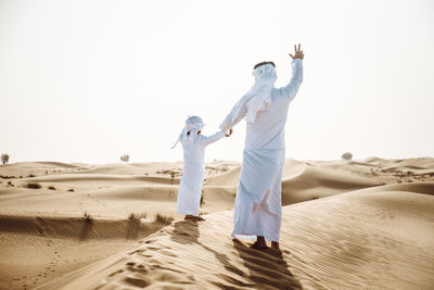 People on beach against clear sky