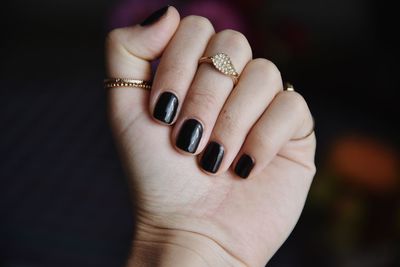 Close-up of woman hand on finger against black background