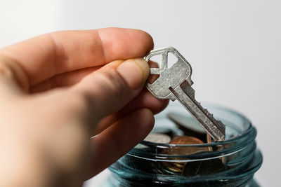 Close-up of hand holding glass against white background