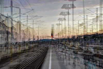 Digital composite image of railroad tracks in city against sky