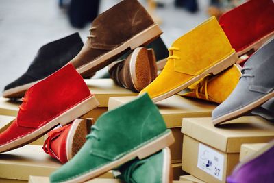 Close-up of multi colored shoes on boxes at shop for sale