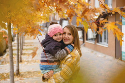 Portrait of smiling young woman standing in park