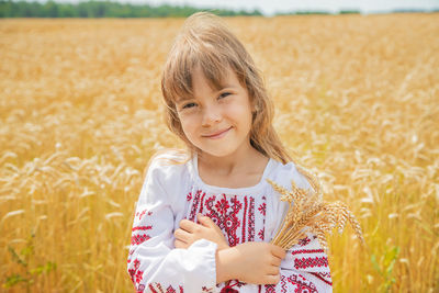 Portrait of young woman standing on field