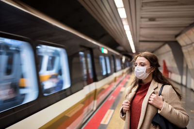 Woman by train at subway station