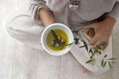 High angle view of hand holding bowl on table