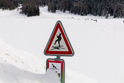 Road sign on snow covered land