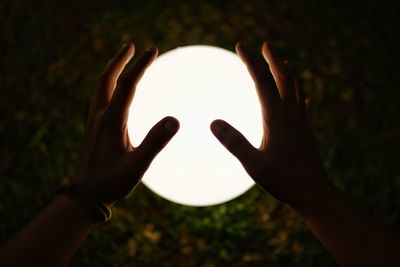 Close-up of person hand against sky