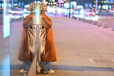 Rear view of women standing on street at night