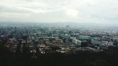 View of cityscape against cloudy sky