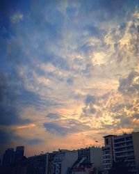Modern cityscape against sky during sunset