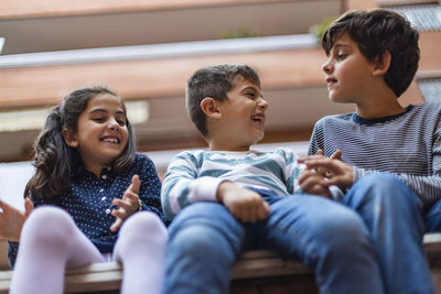 Smiling siblings sitting outdoors