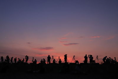 Silhouette people against sky during sunset