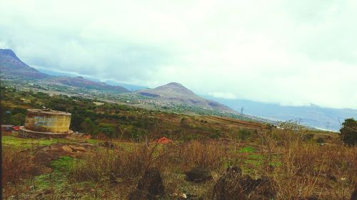 Scenic view of mountains against cloudy sky