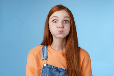 Portrait of woman against blue background