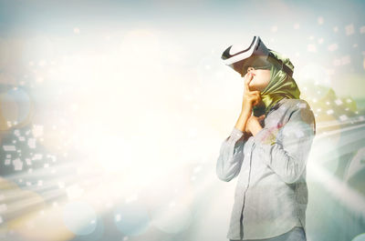 Digital composite image of woman wearing virtual reality against 