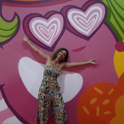 Full length of a young woman standing against the wall