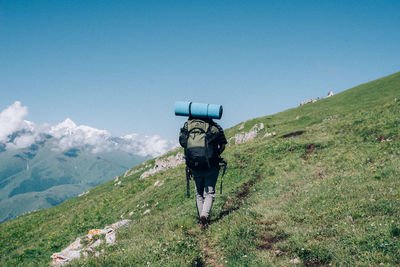 Rear view of man on mountain against sky