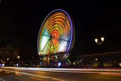Light trails on road against sky at night
