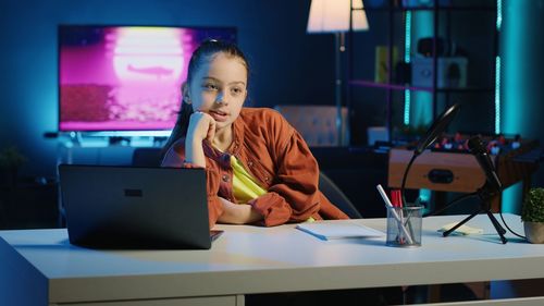 Young woman using laptop at cafe