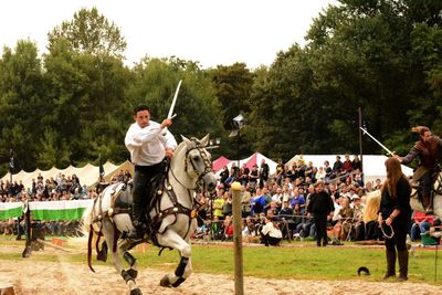 Rear view of man riding horse in park