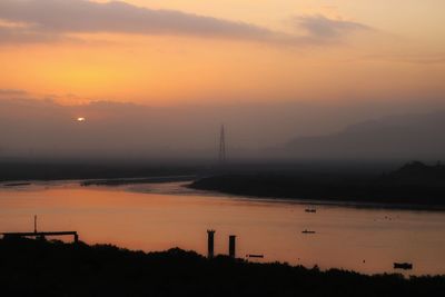 Scenic view of river against sky during sunset