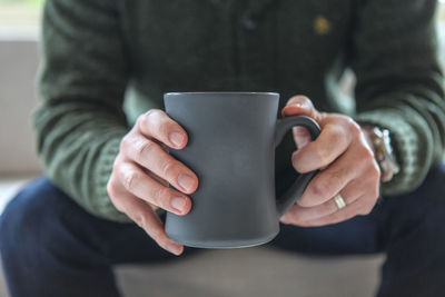 Midsection of man having drink