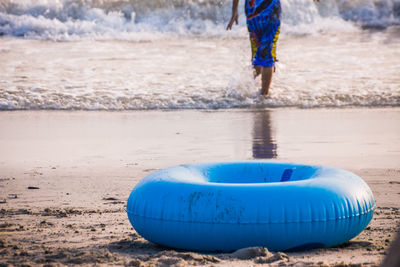 Low section of boy on wet sand at beach