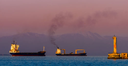 Ship sailing on sea against sky during sunset