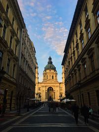 People walking on road amidst buildings in city