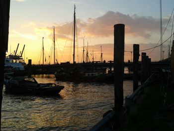 Boats in harbor at sunset