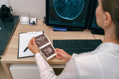 Midsection of woman using digital tablet