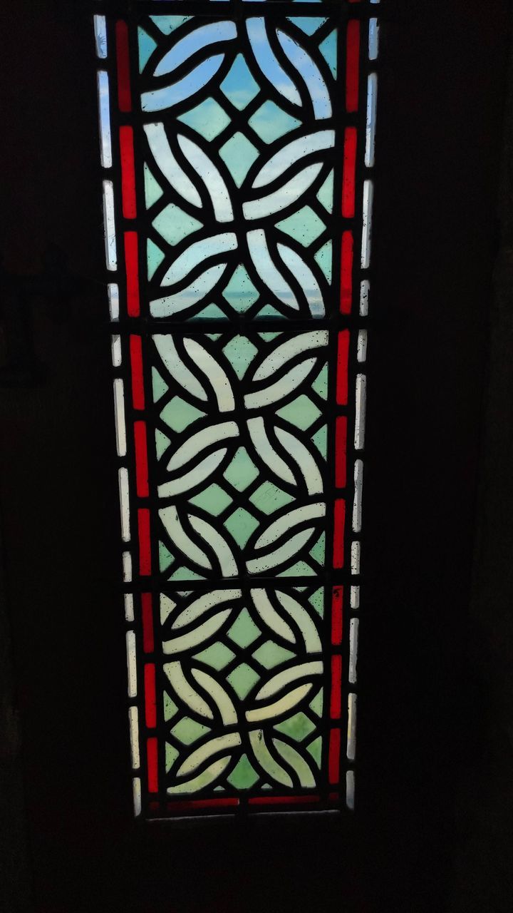 CLOSE-UP OF WINDOW ON MULTI COLORED GLASS WALL