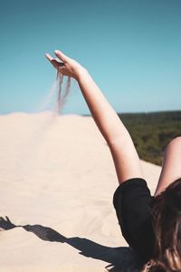 Close-up of woman lying on sand