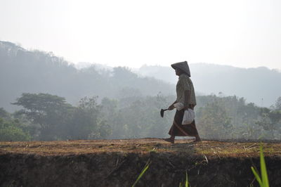 Rear view of woman standing on field