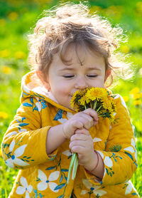 Side view of girl blowing flowers