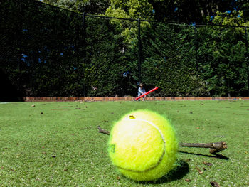Green ball on grass against trees at night