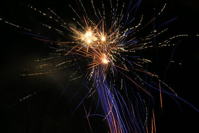 Low angle view of firework display at night