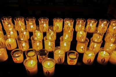 Close-up of illuminated candles on glass