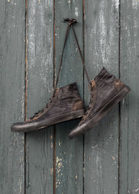 Close-up of shoes hanging on wooden wall