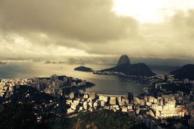 View of cityscape against cloudy sky