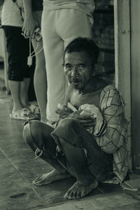 Portrait of senior man sitting on footpath