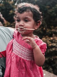 Cute baby girl eating frozen sweet food outdoors