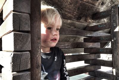 Cute boy sitting in wooden playhouse