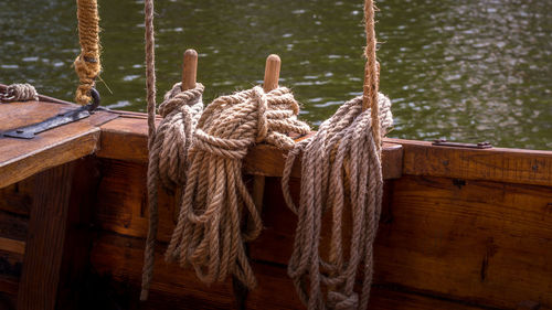 Close-up of rope tied to wooden post in lake