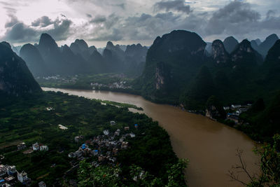 Scenic view of river and mountains against sky