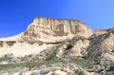 View of rock formation against clear blue sky