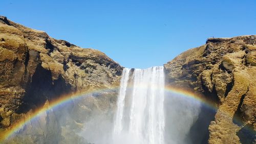 Low angle view of rainbow on waterfall