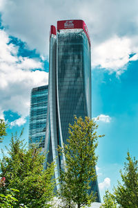 Low angle view of modern building against cloudy sky