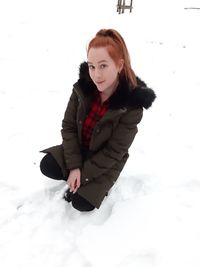 Portrait of woman sitting in snow