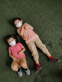 High angle view of boy lying on grass